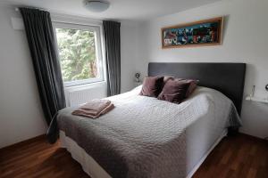 ein Schlafzimmer mit einem Bett mit zwei Kissen und einem Fenster in der Unterkunft Hus i Skärhamn när till hav och natur! in Utäng