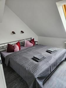 een slaapkamer met een groot bed met rode en roze kussens bij Mittel-Schänke Wieda in Walkenried