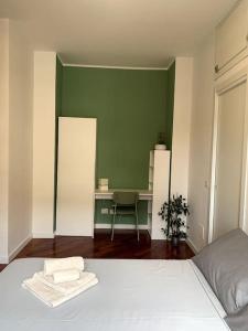1 dormitorio con cama blanca y escritorio en The Green House [Free Private Parking], en Milán