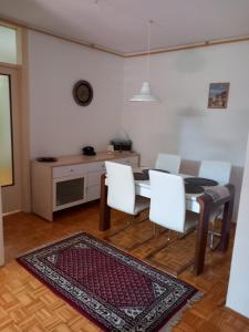 a dining room with a table and white chairs at Stan Breka in Sarajevo +5 photos