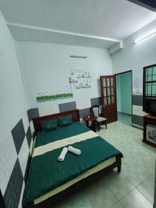 ブンタウにあるMotel Thành Đạtのベッドルーム1室(大型ベッド1台、緑の掛け布団付)