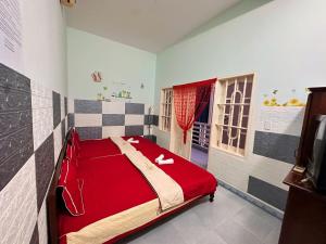a bedroom with a red bed in a room with a window at Motel Thành Đạt in Vung Tau