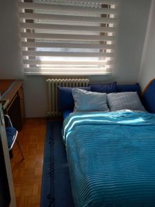 a bed sitting in a room with a window at Stan Breka in Sarajevo