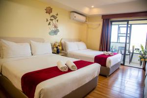 a hotel room with two beds and a balcony at 456 Hotel in Baguio