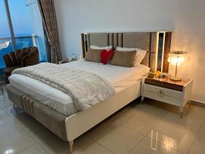 ein Schlafzimmer mit einem großen Bett mit einem roten Herz darauf in der Unterkunft Ft 22 R1 Luxury Room attach bath Seaview Beach access Ajman غرفة فاخرة مع إطلالة على البحر وإمكانية الوصول إلى الشاطئ in Ajman 