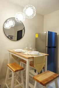 eine Küche mit einem Tisch, einem Kühlschrank und einem Spiegel in der Unterkunft CJ Cozy BnB in Mandaue City