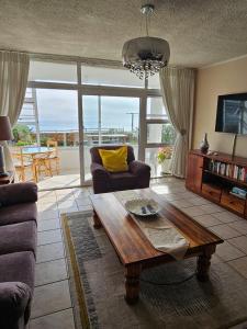 a living room with a couch and a coffee table at Bayview Seafront Apartment in East London