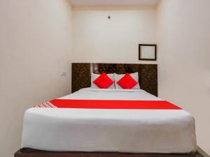 een slaapkamer met een groot bed met rode kussens bij OYO Hotel Apoorva in Shamshabad