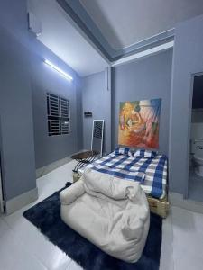 1 dormitorio con 1 cama y una pintura en la pared en Nhà Nghỉ Thành Đạt, en Can Tho