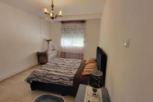 a bedroom with a bed and a window and a chandelier at Joli appartement au centre in Annaba