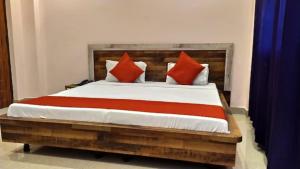 una camera da letto con un grande letto con cuscini rossi di Hotel Aradhya Gange Residency Tapovan Rishikesh - Excellent Service Awarded a Narendranagar
