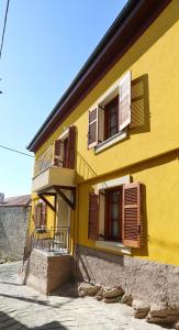 a yellow building with windows and a balcony at Kallichoron 3 in Kavála