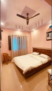 a bedroom with a bed with a ceiling fan at Hotel Aradhya Gange Residency Tapovan Rishikesh - Excellent Service Awarded in Narendranagar