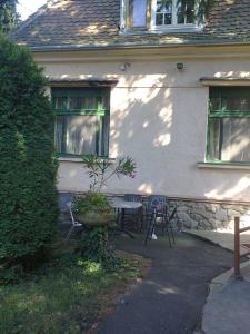 a table and chairs in front of a house at Alpesi Trimmel Vendégház in Sopron