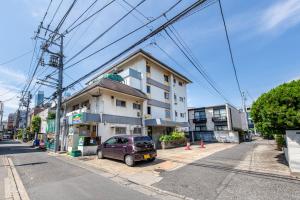 東京にあるFufu House Tokyo Shin-Okuboの建物前に駐車した紫色の車