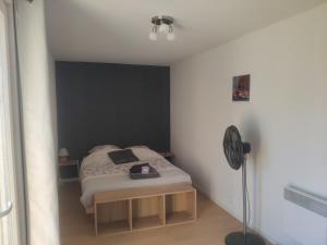 a small bedroom with a bed and a fan at Aux amoureux de Provence in Fox-Amphoux +11 photos