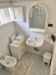 a bathroom with a sink and a toilet and a mirror at Appartamento Meri, Montecatini Terme in Montecatini Terme