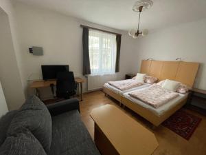 sala de estar con 2 camas y escritorio en Alpesi Trimmel Vendégház, en Sopron