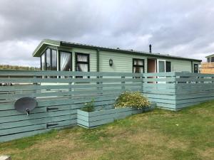 a blue house with a fence in front of it at No 70 in Newton Stewart