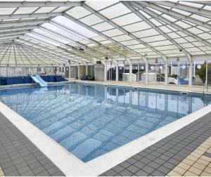 a large swimming pool with a glass ceiling at Pets Stay free 2 bedroom caravan at heacham beach in Hunstanton