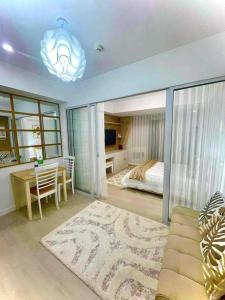 1 dormitorio con cama, mesa y sofá en Azure Tropical Getaway (Netflix and Wi-fi), en Manila