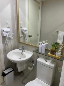 y baño con lavabo, aseo y espejo. en Azure Tropical Getaway (Netflix and Wi-fi), en Manila