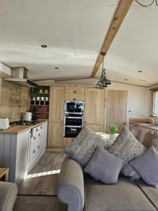 ein Wohnzimmer mit Couch und Küche in der Unterkunft Premium 2 Bedroom Caravan with Free Wifi in Hunstanton
