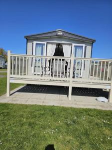 eine weiße Veranda mit weißem Geländer und Gras in der Unterkunft Premium 2 Bedroom Caravan with Free Wifi in Hunstanton