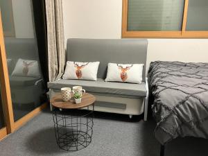 een slaapkamer met een bank met 2 kussens en een tafel bij Akane Shimada House - Vacation STAY 13990 in Narashino