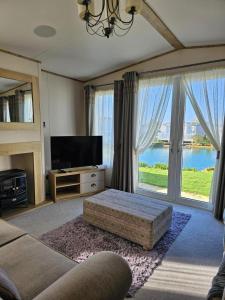 ein Wohnzimmer mit einem TV und einem großen Fenster in der Unterkunft Premium 2 Bedroom Caravan with Free Wifi in Hunstanton + 15 Fotos