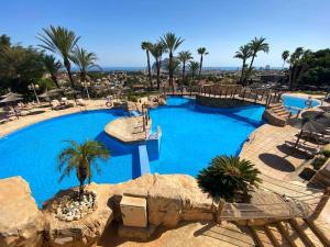 a large pool at a resort with palm trees at Tucan Apartment: Sea View, 6 Pools, Terrace in Calpe