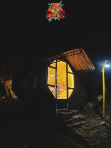 a small house with a light in the dark at Woodman Hideout in Kanthalloor