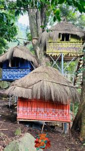 a building with a straw roof and a hut at Woodman Hideout in Kanthalloor