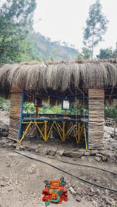 a hut with a straw roof with a sign on it at Woodman Hideout in Kanthalloor