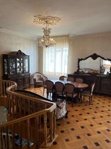 uma sala de jantar com uma mesa e cadeiras e um lustre em Guest house Sheri em Telavi
