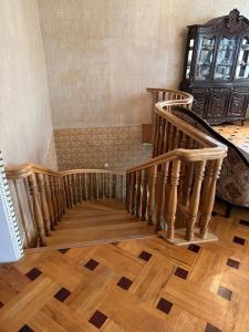 uma escada num quarto com pisos em madeira em Guest house Sheri em Telavi