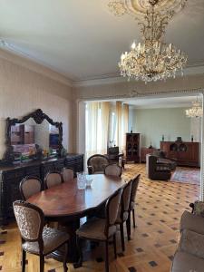 uma sala de jantar com uma mesa e cadeiras e um lustre em Guest house Sheri em Telavi