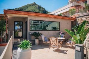 a patio with a table and chairs and a mountain at Taormina Seaview - Luxury Apartment in Taormina in Taormina