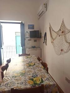 comedor con mesa, sillas y TV en Casa Spaziosa al centro di Ustica, en Ustica