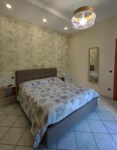 a bedroom with a bed and a chandelier at B&B Casa Mena in Vietri sul Mare