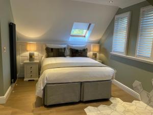 Schlafzimmer mit einem großen Bett und einem Dachfenster in der Unterkunft Brand New! Bagpipers Luxury Hideaway at Ard Craig House Glencoe in Glencoe