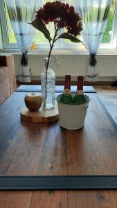 a wooden table with a vase with a flower in it at Ferienwohnung Sylke in Marienwerder