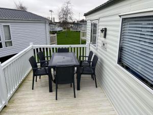 a patio with a table and chairs on a balcony at Luxury 3 bed Caravan at Manor Park Pets go Free in Hunstanton