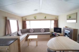 a living room with a couch and a tv at 2 bedroom caravan in hunstanton free wi-fi in Hunstanton