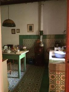 uma cozinha com um lavatório e uma mesa em Casa nel bosco a 10 minuti da Pistoia em Corbezzi