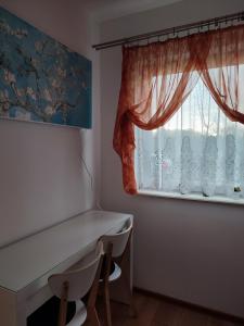 a room with a window with a table and chairs at Mieszkanie z ogrodem in Gdańsk