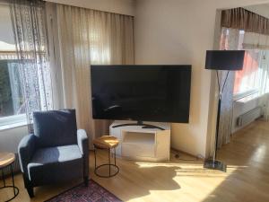 un salon avec une grande télévision et une chaise dans l'établissement 2 floor apartment with 3 bedrooms, 6 beds, à Närpiö