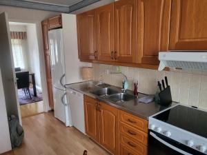 - une cuisine avec des placards en bois et un évier dans l'établissement 2 floor apartment with 3 bedrooms, 6 beds, à Närpiö
