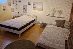 een slaapkamer met een bed en een bank bij Ferienhaus im Moor in Wiesmoor