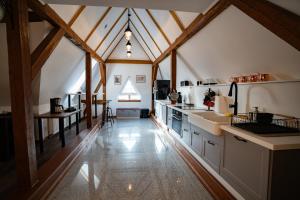 a kitchen with white counters and a ceiling with wooden beams at Apartament Loftowy Ordona 5 in Szczecinek +17 photos